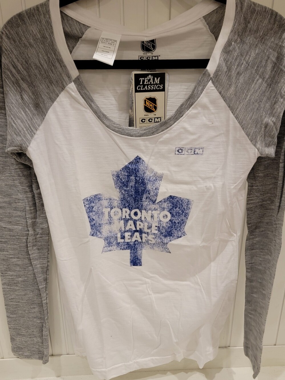 CCM Women’s White Tee with Gray Sleeves and Blue Maple Leaf Logo